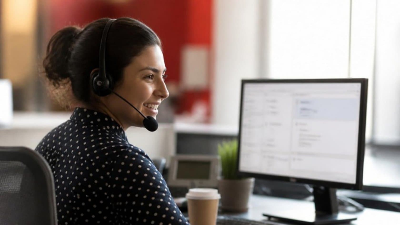 Customer service agent with a headset helping a caller with a support ticket on screen