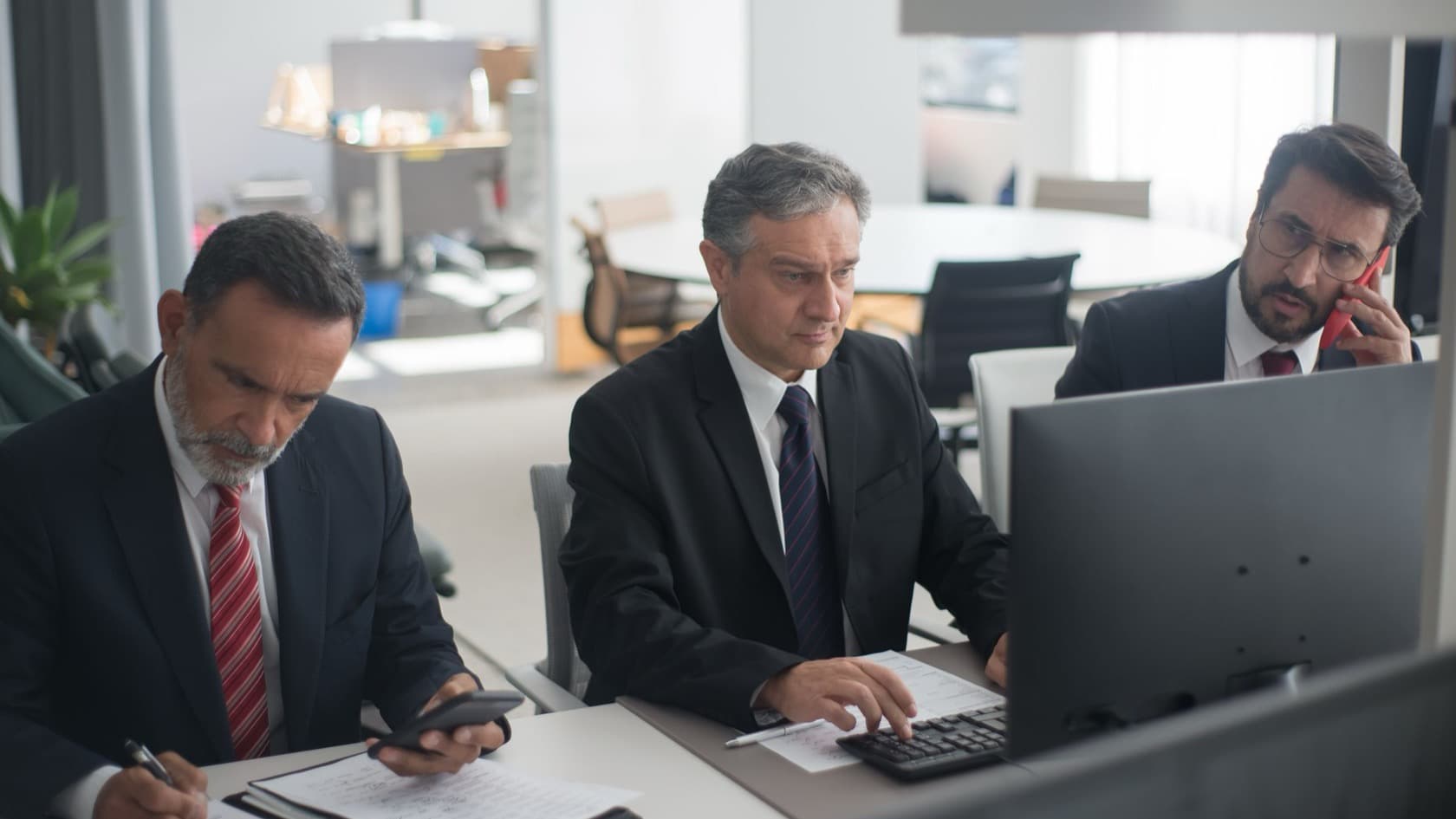 Accounts team at their desks working through statements, one on a phone call