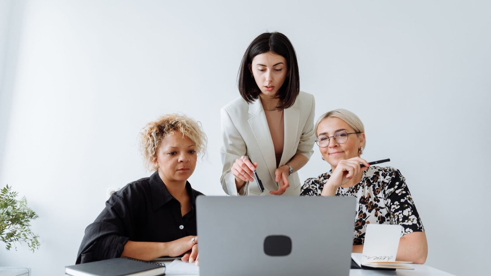 Three colleagues reviewing a draft together on a laptop