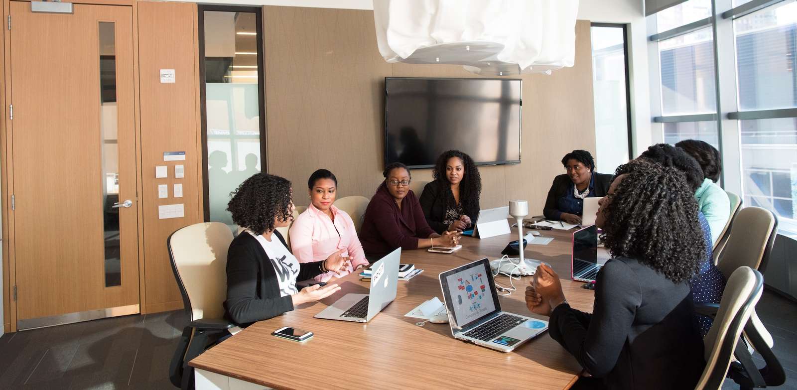 Project team meeting around a conference table with laptops